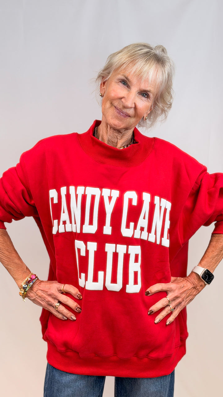 Woman wearing red mock neck sweatshirt with &
