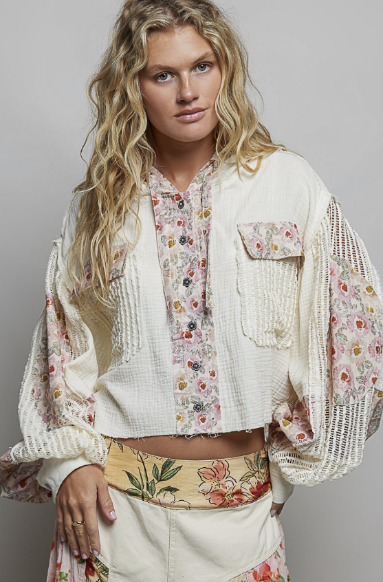 Woman wearing beige and floral waffle knit hoodie on plain background