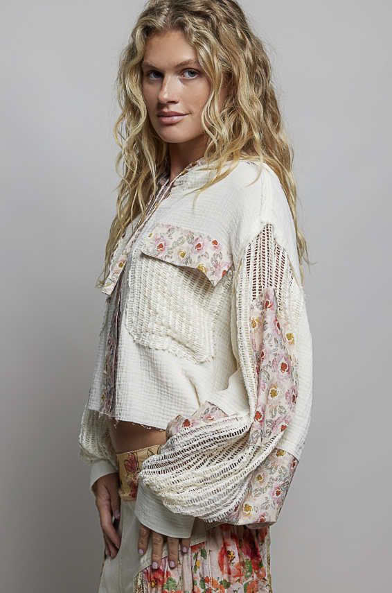 Woman wearing beige and floral waffle knit hoodie on plain background