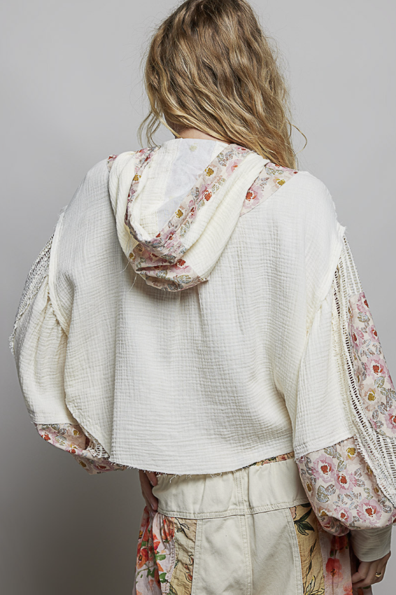 Woman wearing beige and floral waffle knit hoodie on plain background