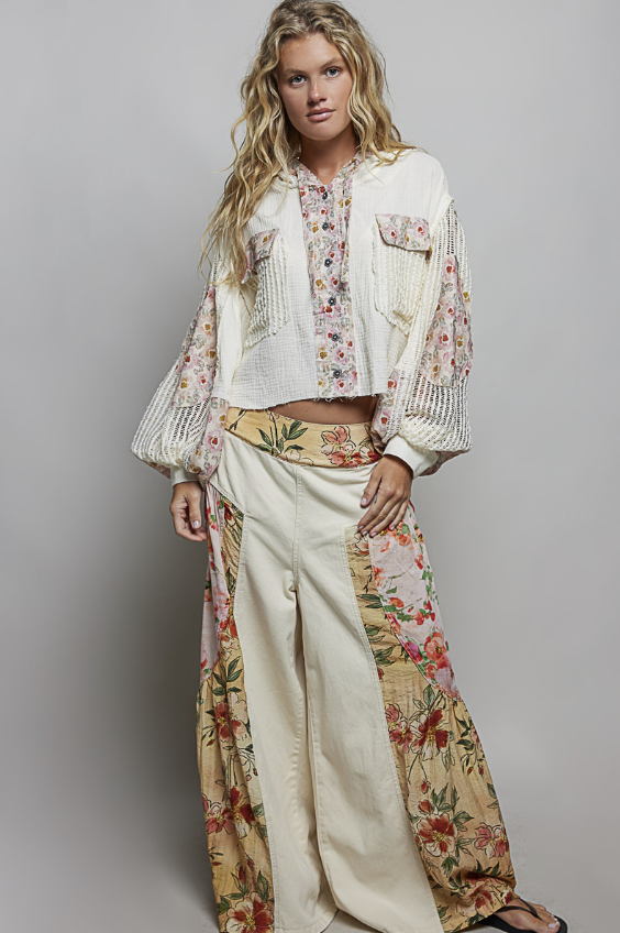 Woman wearing beige and floral waffle knit hoodie on plain background