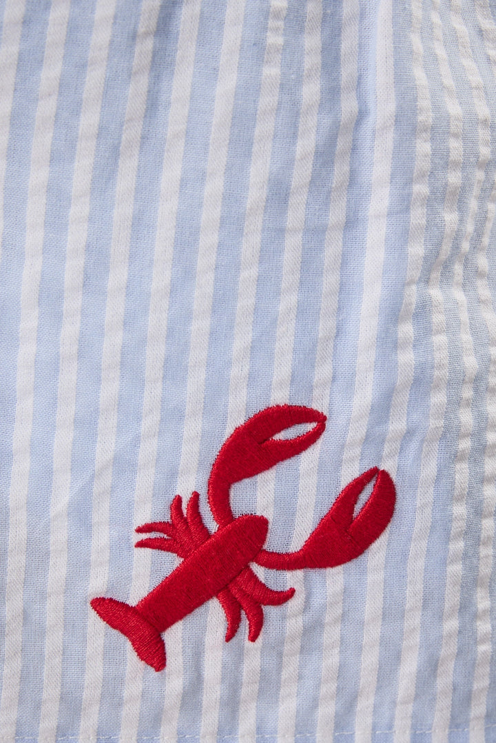 Red lobster embroidery on a blue and white striped fabric background