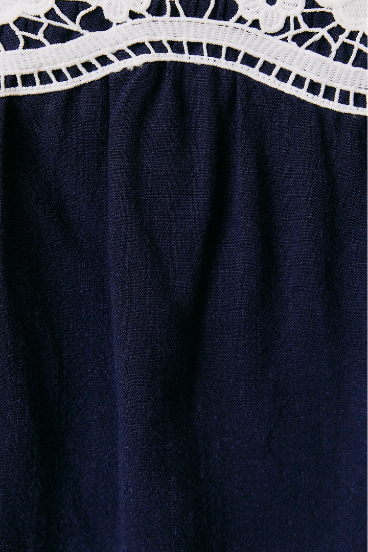 Navy blue fabric with white lace trim at the top