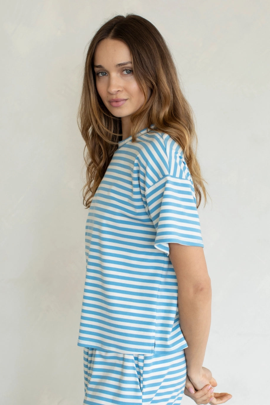 Woman wearing blue and white stripe shirt on plain background