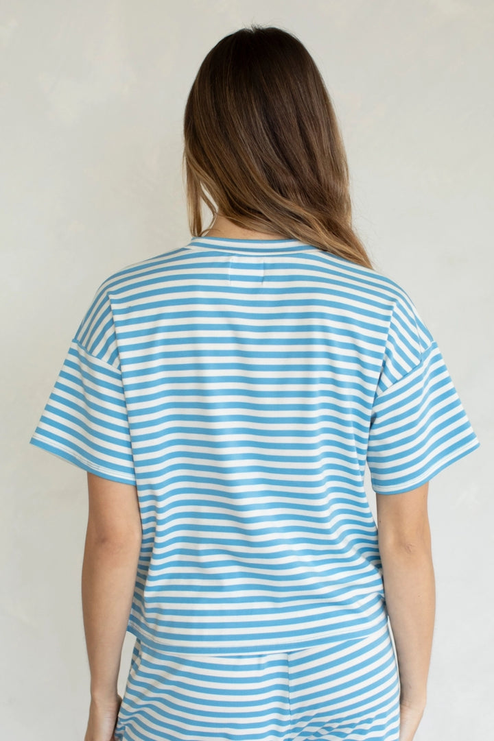 Person wearing a blue and white striped shirt against a plain background