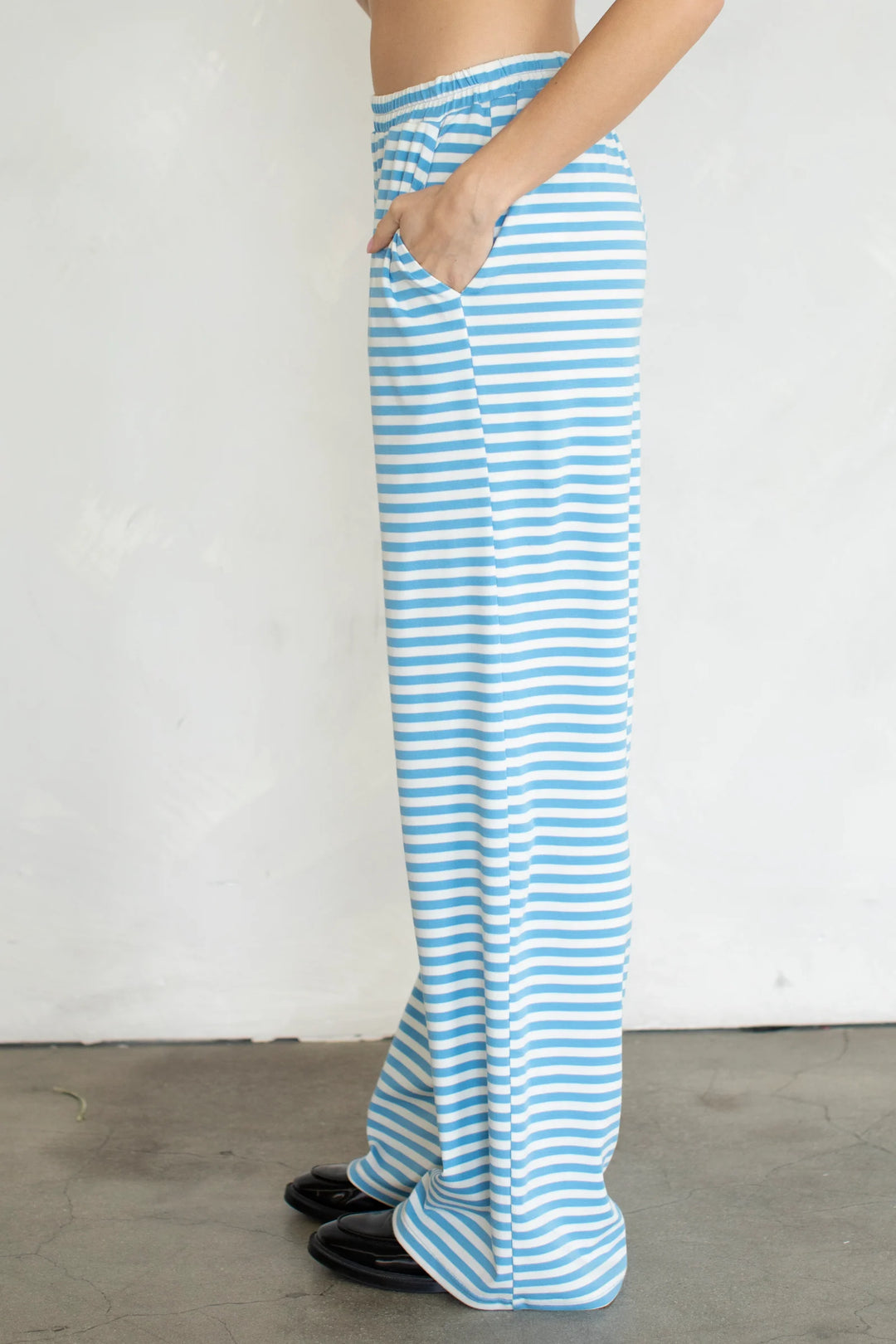 Person wearing blue and white striped pants against a plain background