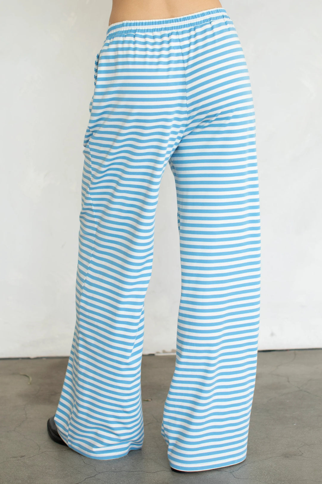 woman wearing blue and white stripe pants on plain background