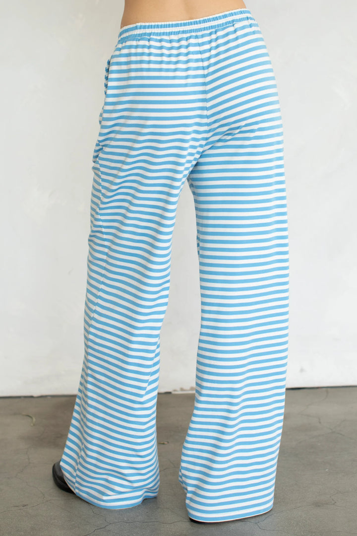 woman wearing blue and white stripe pants on plain background