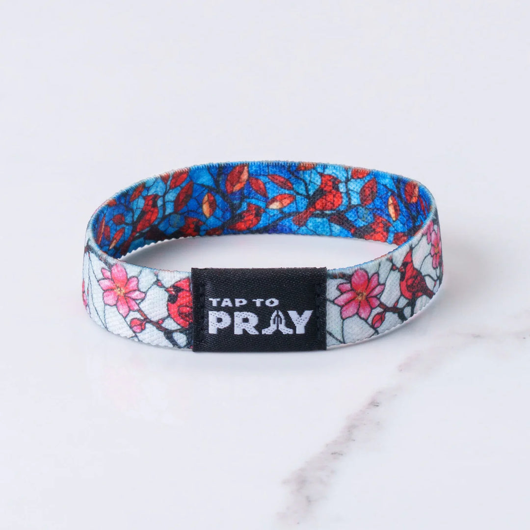 Floral patterned wristband with 'Tap to Pray' label on a white background