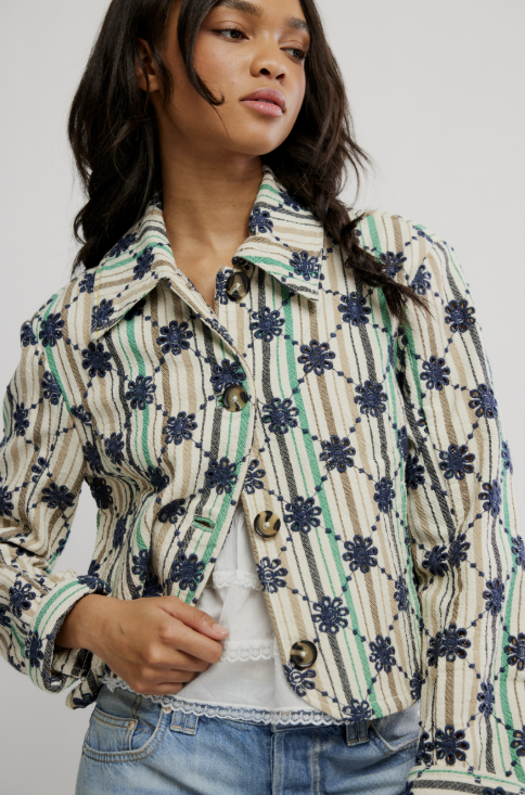 Woman wearing a patterned jacket with a plain background