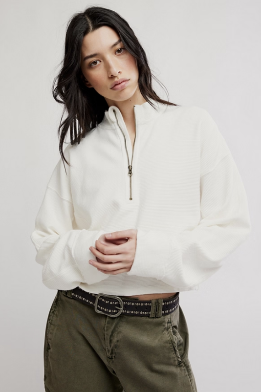 Woman wearing white top and green pants on white background