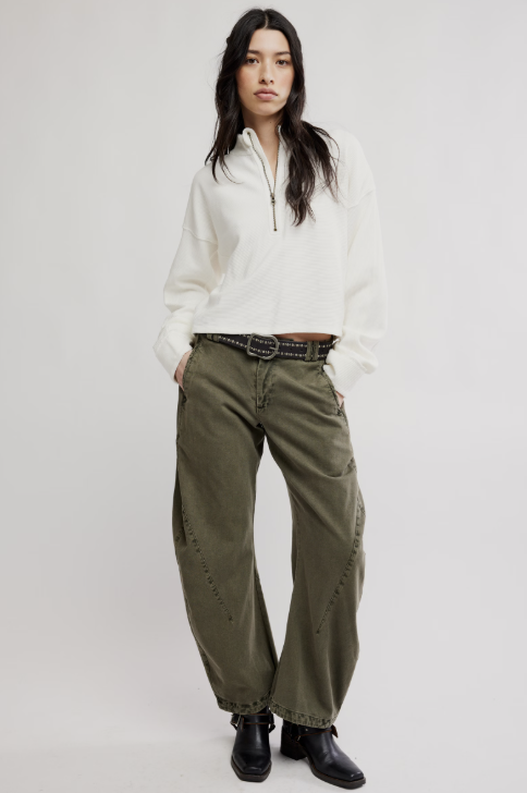 Woman wearing white top and green pants on white background