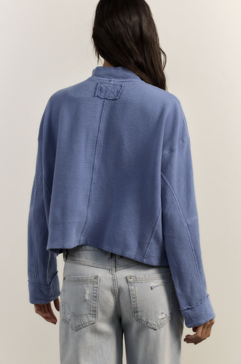 Woman wearing blue top and jeans on white background
