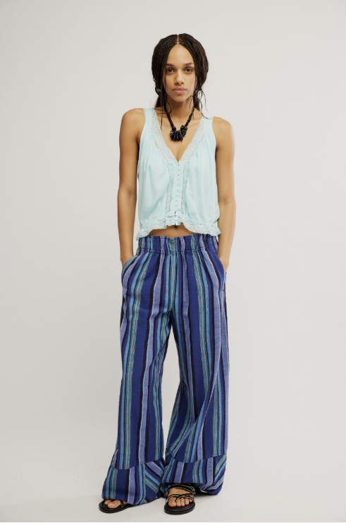 Woman wearing blue tank and blue pants on white background