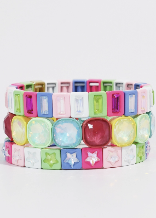 Bracelet stack including bright colors and gemstones on white background