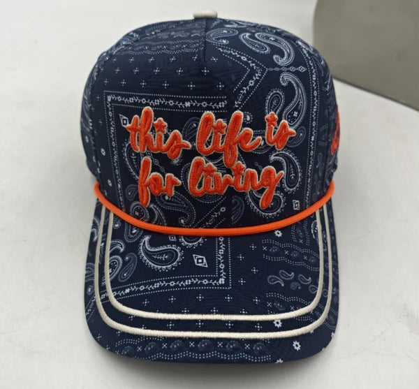 Navy blue bandana-patterned cap with orange text on a white background