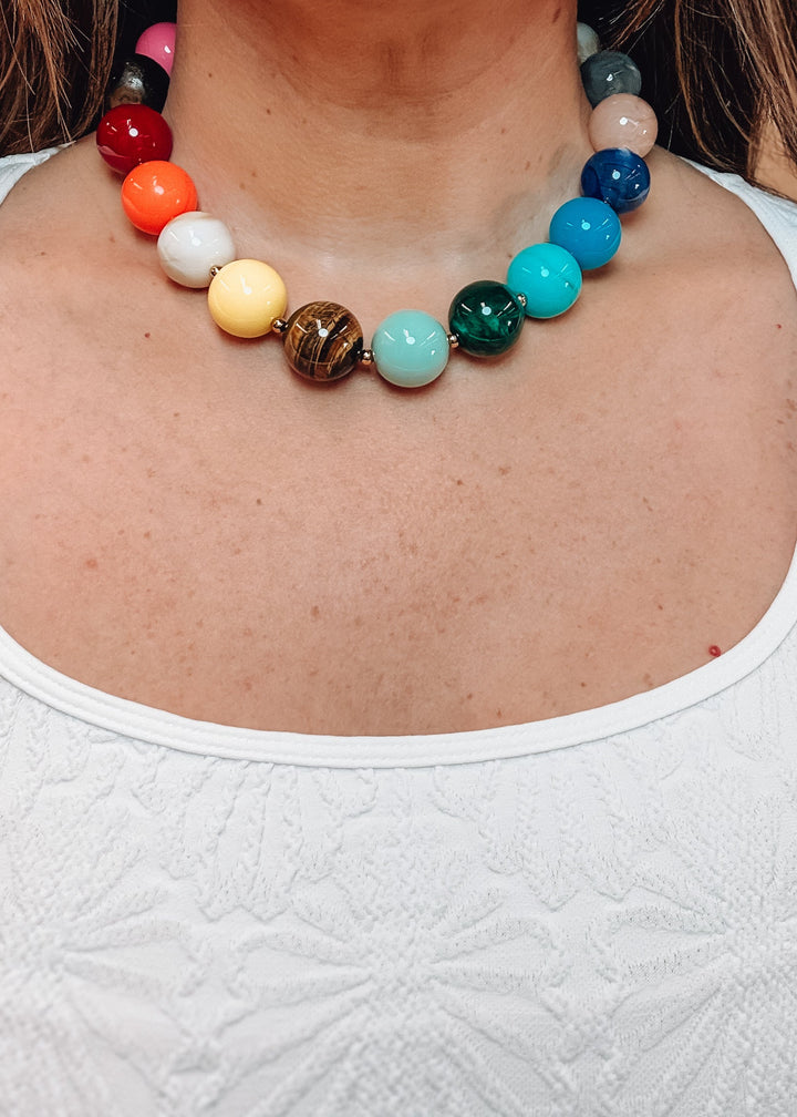 Woman wearing white shirt and colorful beaded necklace