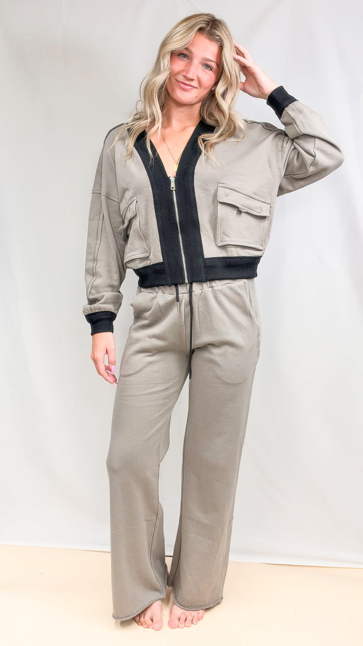 Woman wearing matching beige set with black details on plain background