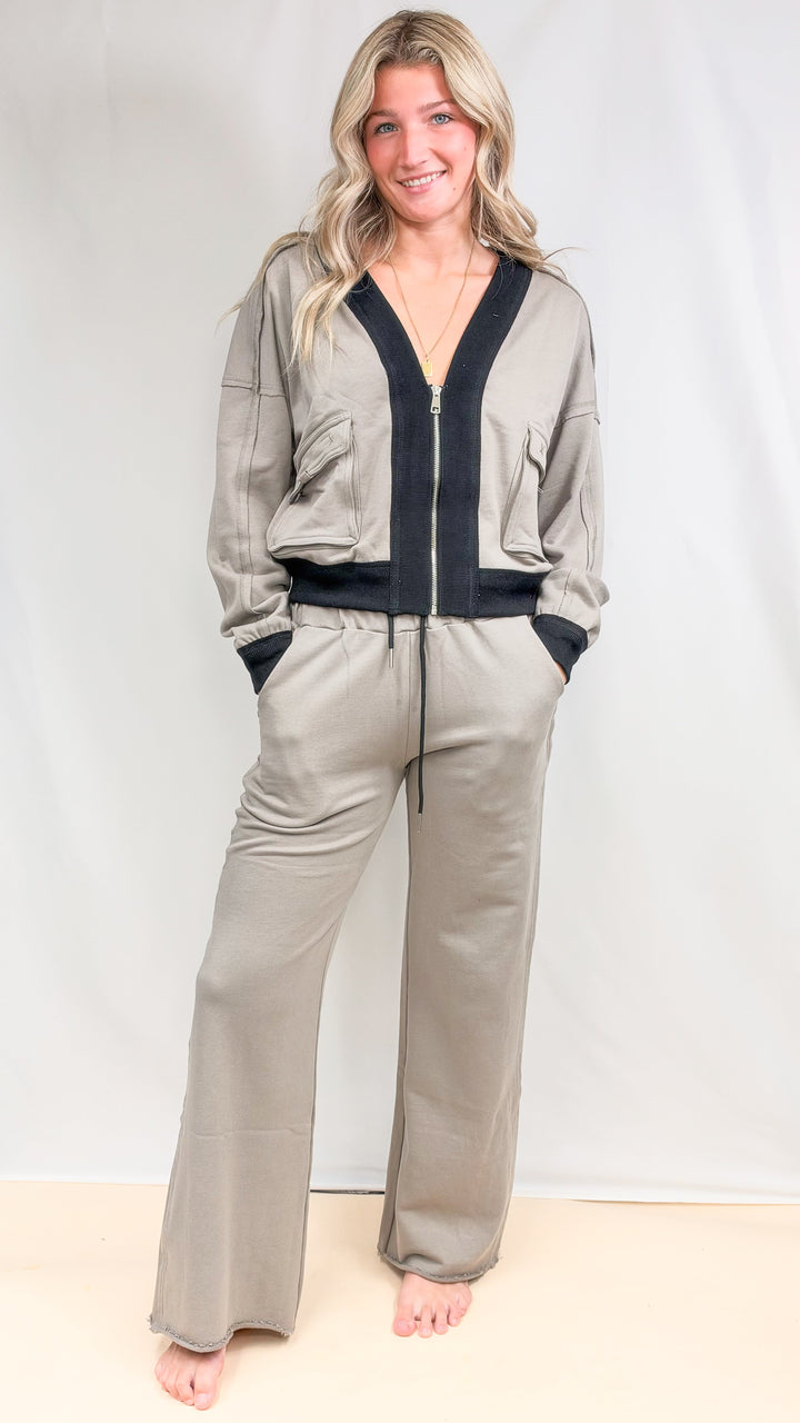 Woman wearing matching beige set with black details on plain background