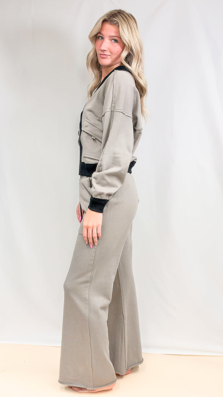 Woman wearing matching beige set with black details on plain background