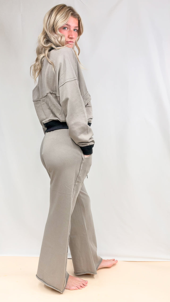 Woman wearing matching beige set with black details on plain background