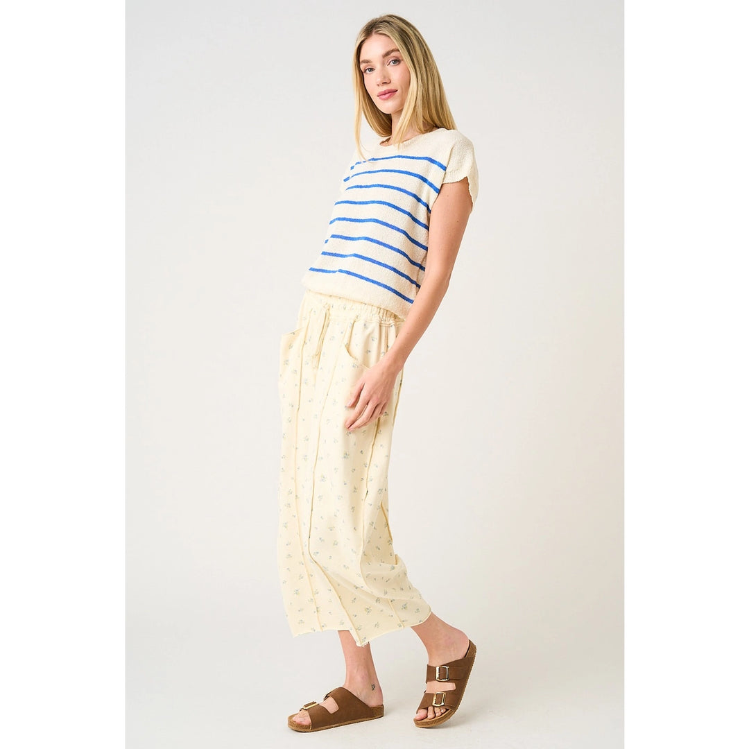 Woman wearing a striped shirt and light-colored pants on a white background