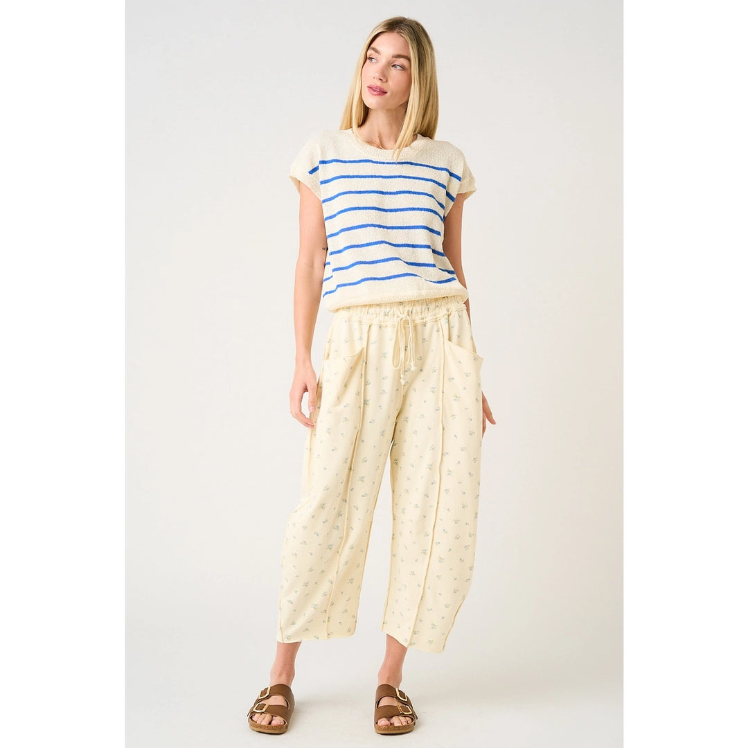 Woman wearing a striped shirt and light-colored pants on a white background
