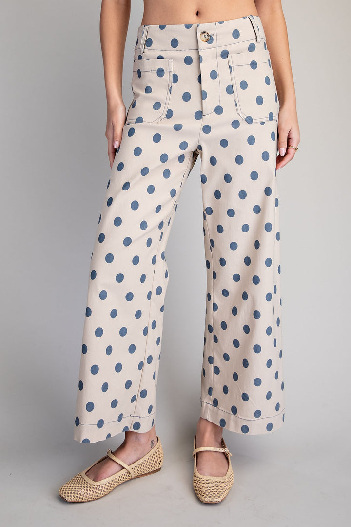 Polka dot pants worn by a person on a gray background