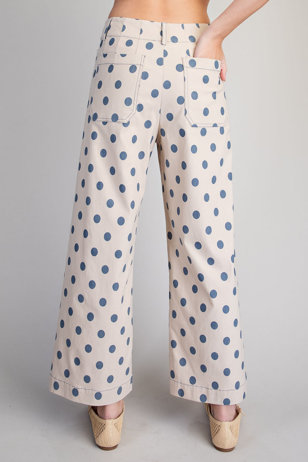 Polka dot pants worn by a person on a plain background