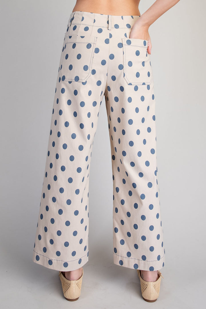 Polka dot pants worn by a person on a plain background