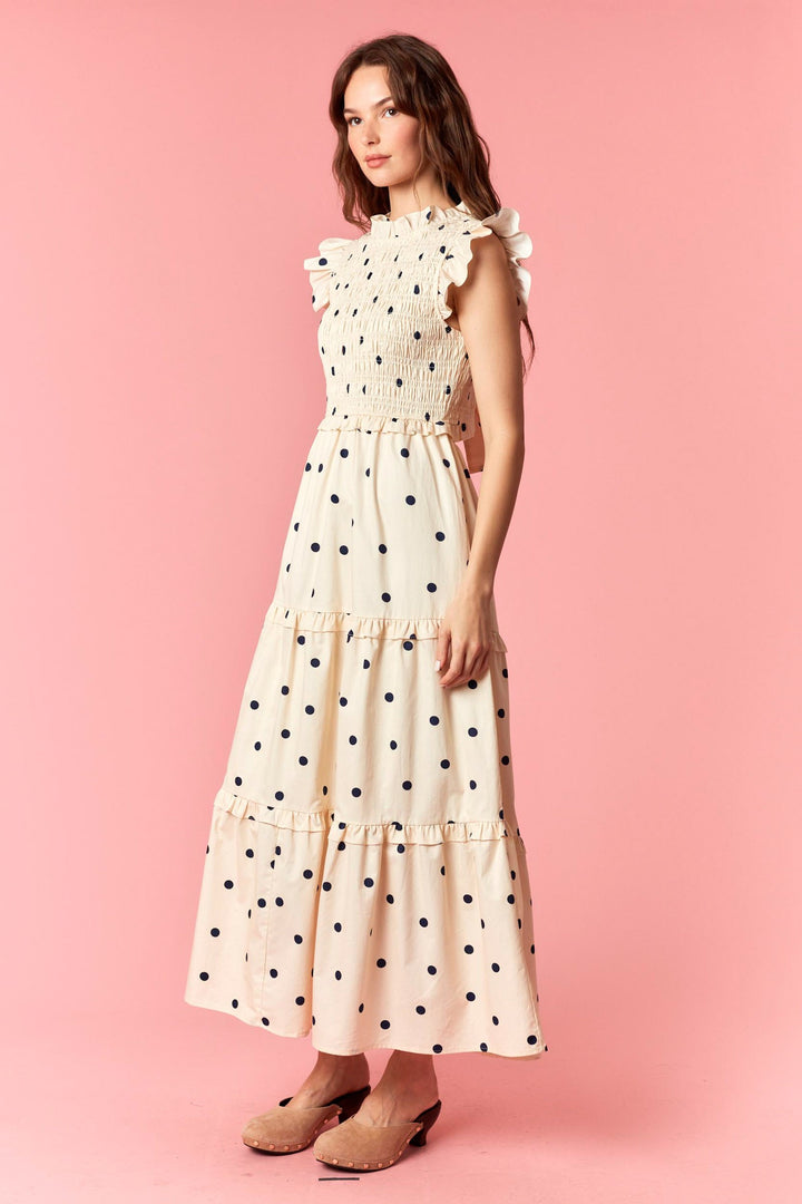 Woman wearing a polka dot dress on a pink background