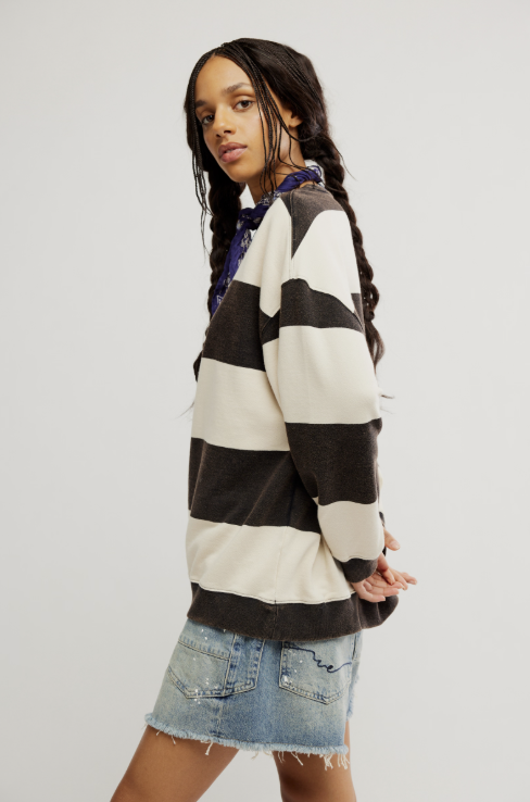 Woman wearing black and white stripe crewneck with denim shorts on white background