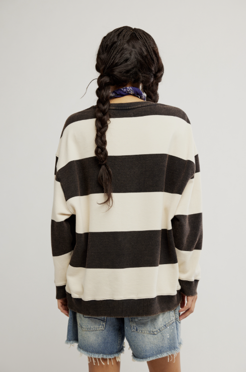Person wearing a black and white striped sweater on a plain background