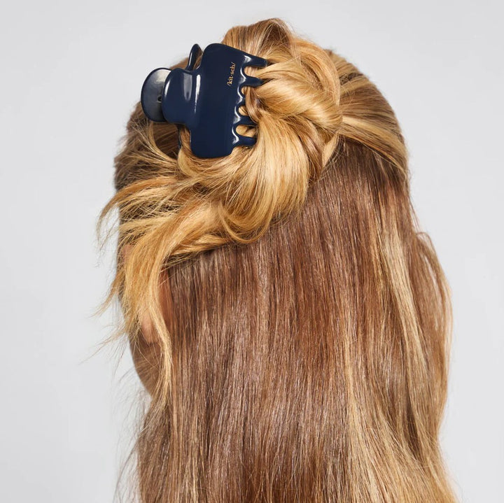 Blue claw clip in hair on plain background