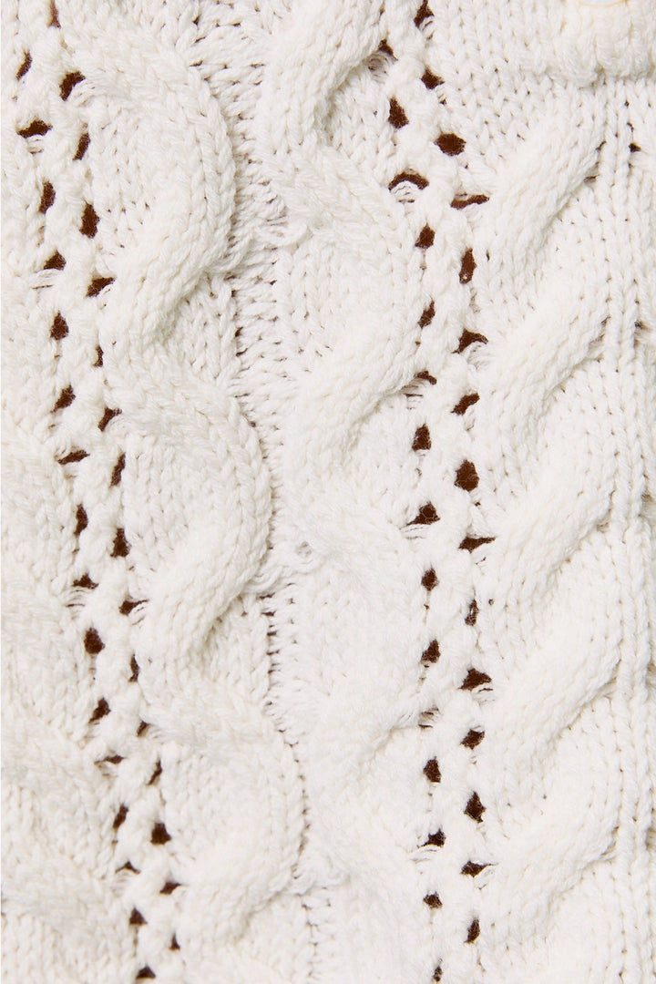 Close up of white cable knit sweater