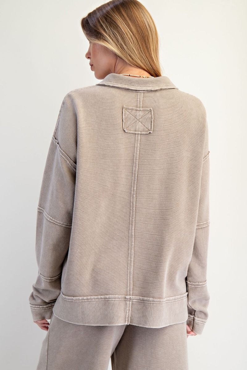 Person wearing a beige jacket with a pocket on a white background