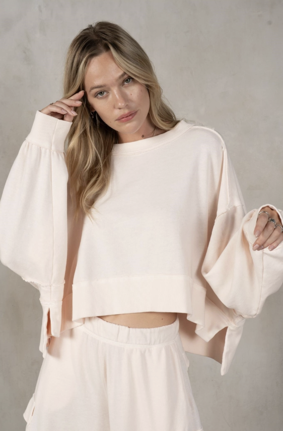 woman wearing butter sweatshirt on plain background