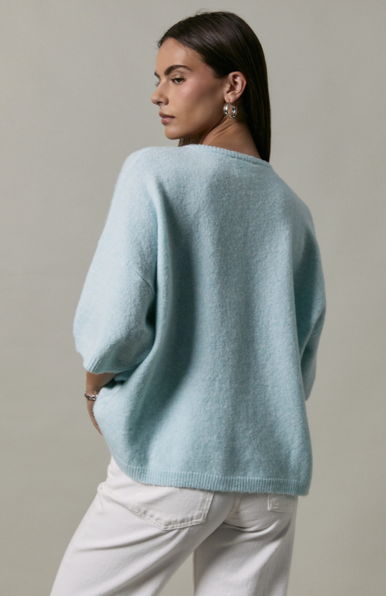 Woman wearing a light blue sweater against a neutral background