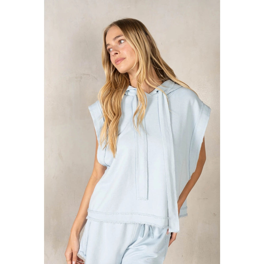 Woman wearing light blue matching set on plain background