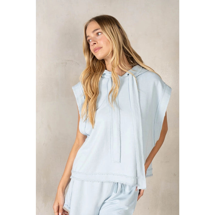 Woman wearing light blue matching set on plain background