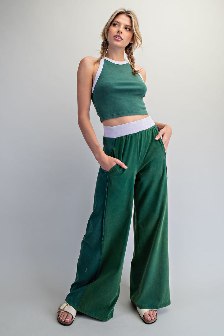 Woman wearing a green and white outfit on a plain background