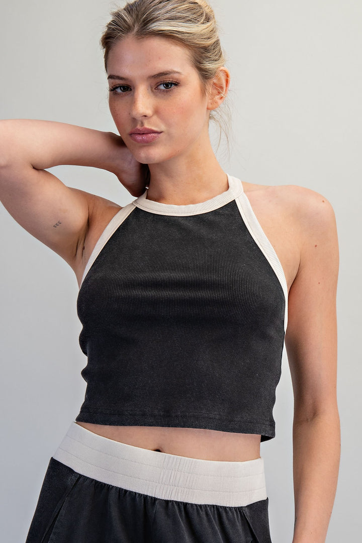 Woman wearing a black and white tank top against a plain background