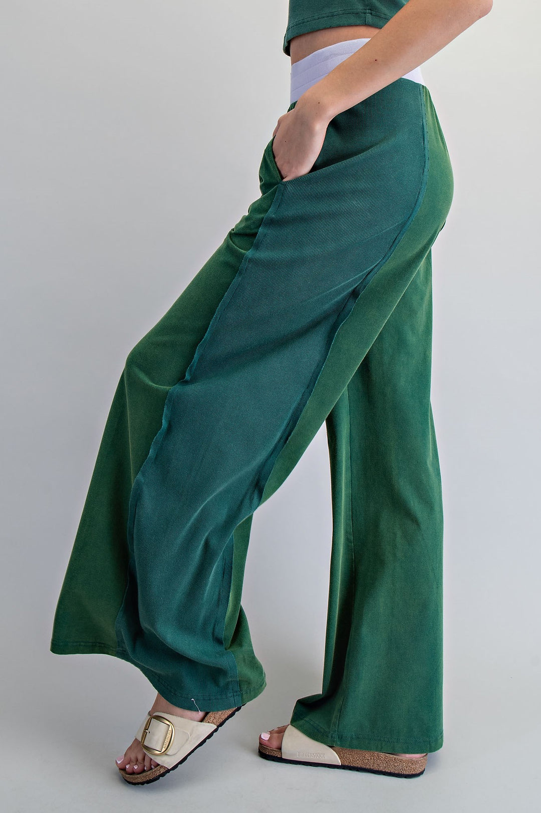 Green wide-leg pants worn by a person on a plain background
