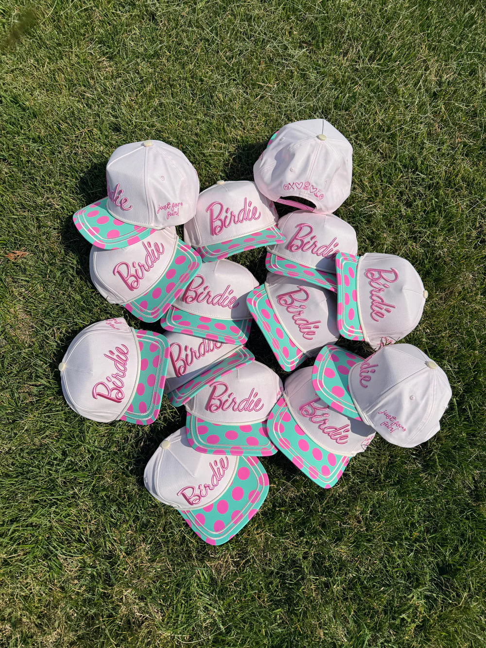 Collection of white caps with pink and green polka dots and &