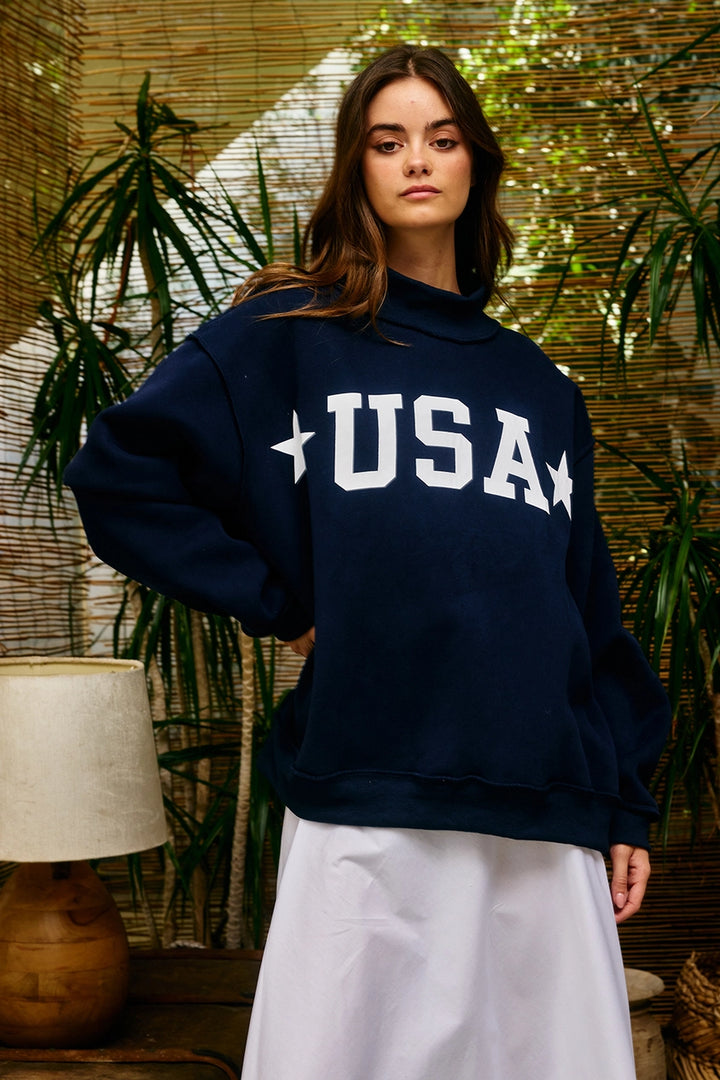 Person wearing a navy blue sweatshirt with &