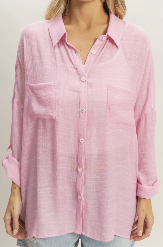 Pink button-up shirt worn by a person on a plain background