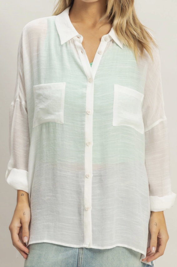 Light green and white sheer blouse worn by a person on a plain background