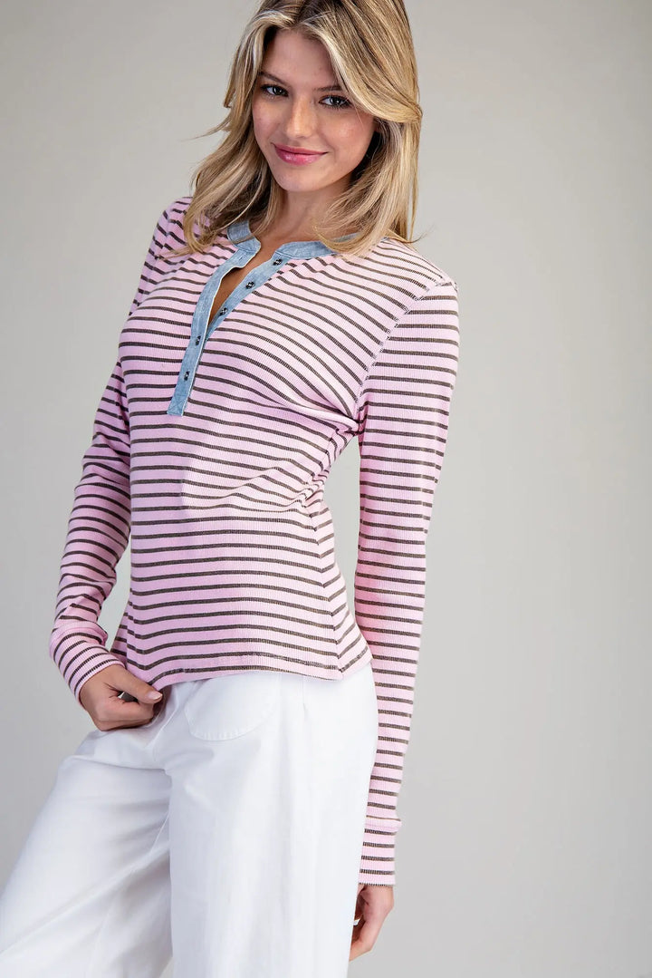 Woman wearing a striped long-sleeve top with a gray background