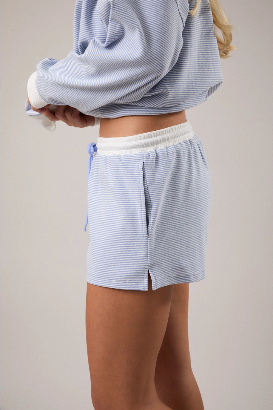 Woman wearing blue and white stripe matching set on plain background