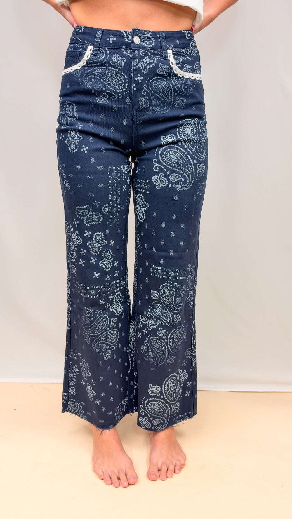 Woman wearing navy bandana print pants on plain background